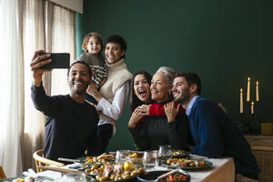 Smiling family taking selfie on smart phone at home - EBSF03794