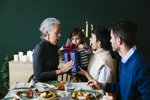 Überrumpelte Großmutter, die ihrem Enkel zu Hause ein Weihnachtsgeschenk macht - EBSF03800