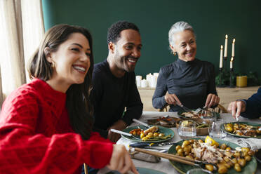 Lächelnde Familie beim gemeinsamen Abendessen im Esszimmer - EBSF03808