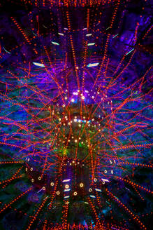 Germany, Bavaria, Wurzburg, Multiple exposure of spinning carousel at night - NDF01588
