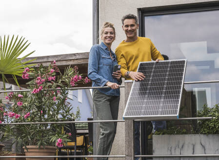 Ehepaar installiert Sonnenkollektor auf dem Balkon - UUF30167