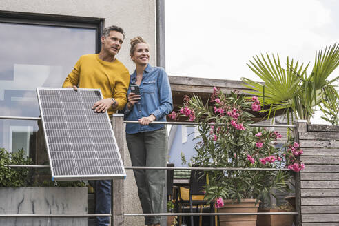 Ehepaar installiert Sonnenkollektor auf dem Balkon - UUF30168