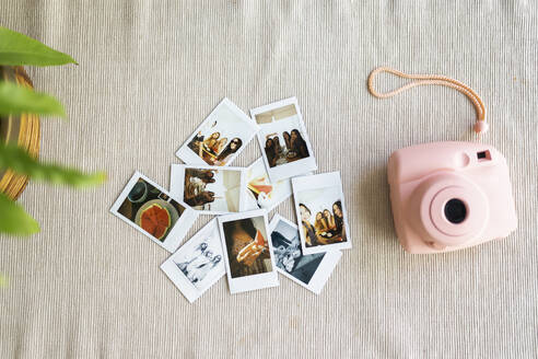 Pink instant camera next to photographs - JPTF01281