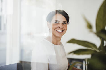 Happy businesswoman with short hair in office - JOSEF20778