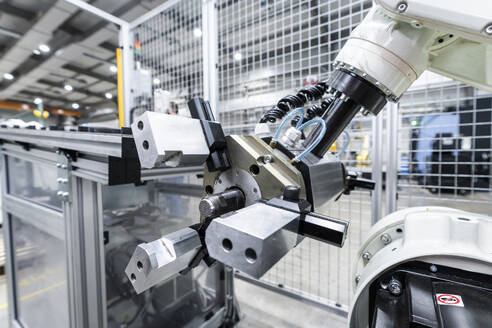 Weißer Roboterarm mit Maschinen in einer Fabrik - AAZF00923