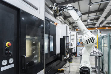 Weißer Roboterarm mit CNC-Maschinen in der Fabrik - AAZF00927