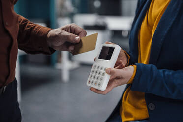 Hand of businessman doing contactless payment at work place - JOSEF20912