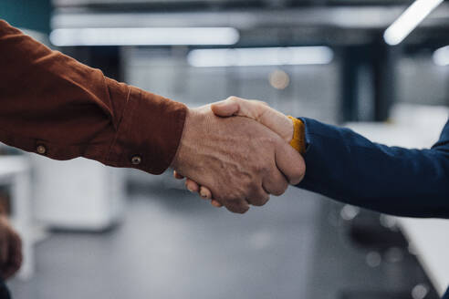 Hands of business colleagues shaking hands at work place - JOSEF20913