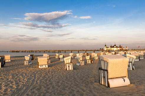 Deutschland, Mecklenburg-Vorpommern, Ahlbeck, Strandkörbe mit Kapuze am leeren Strand in der Abenddämmerung - EGBF00910