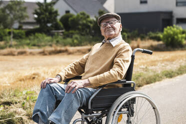 Älterer Mann mit Brille sitzt im Rollstuhl - UUF30246