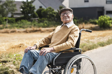 Senior man with eyeglasses sitting in wheelchair - UUF30246