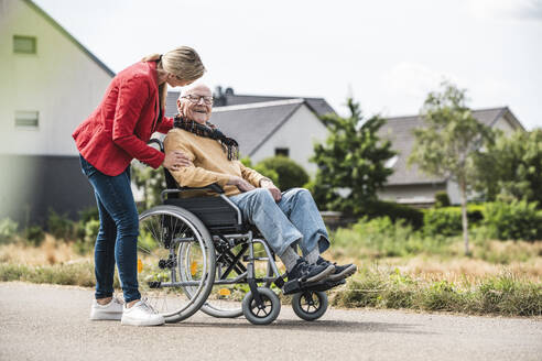 Frau im Gespräch mit einem älteren Mann im Rollstuhl - UUF30252