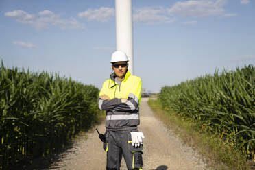 Engineer standing with arms crossed on sunny day - EKGF00482