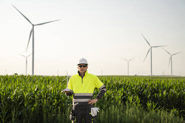 Engineer holding wind turbine model in field - EKGF00538