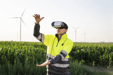 Ingenieur gestikuliert mit Virtual-Reality-Simulator im Feld - EKGF00543