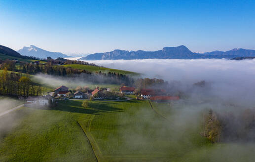 Österreich, Oberösterreich, Drohnenaufnahme von dichtem Nebel hinter kleinem Dorf - WWF06329