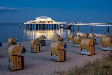 Deutschland, Schleswig-Holstein, Timmendorfer Strand, Strandkörbe mit Kapuze mit Seebrücke und Mikado Teehaus im Hintergrund - EGBF00922