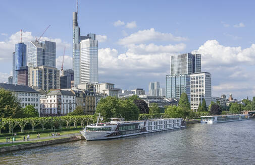 Deutschland, Hessen, Frankfurt, Schiff am Fluss mit Wolkenkratzern in der Innenstadt im Hintergrund - PVCF01380