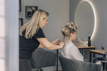 Friseurin kämmt die Haare einer Frau im Salon - EVKF00049