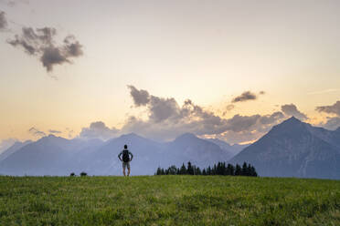 Man admiring mountain range at sunset - DIGF20560