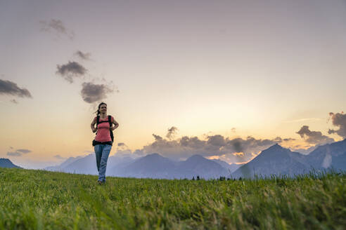 Wanderer im Gras vor einer Bergkette - DIGF20565