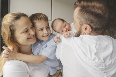 Happy parents carrying children at home - IHF01663