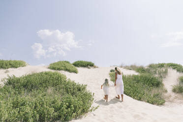 Mutter und Tochter spazieren am Strand an einem sonnigen Tag - SIF00834