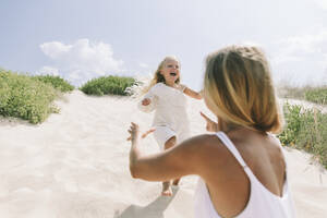 Cheerful daughter running towards mother at beach - SIF00839