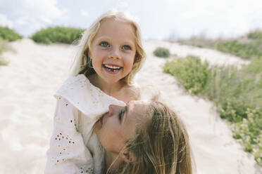 Liebevolle Mutter mit lächelnder Tochter am Strand - SIF00840