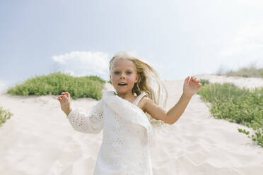 Playful girl with arms raised running at beach - SIF00844