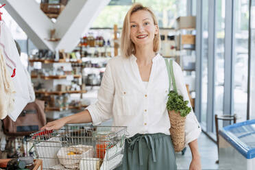 Happy woman shopping groceries in store - NDEF01079