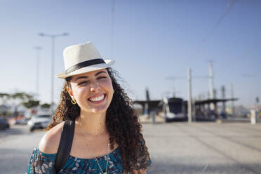 Happy woman wearing hat on sunny day - DCRF01849