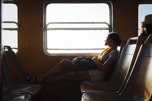 Woman with backpack relaxing in train - DCRF01881