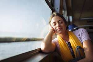 Woman relaxing on train window sill - DCRF01883