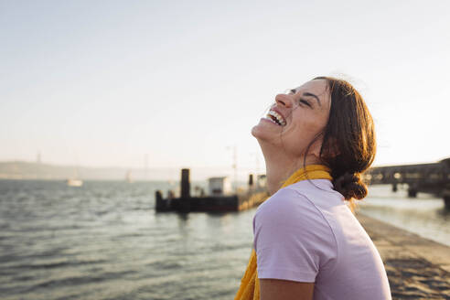 Happy young woman laughing at the waterfront at promenade - DCRF01904