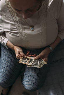 Ältere Frau betrachtet vergangene Fotos in ihrer Wohnung - EGHF00778