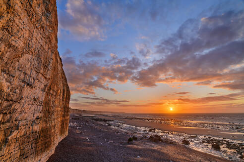 Chalk cliffs near coastline at sunset under cloudy sky - ANSF00603