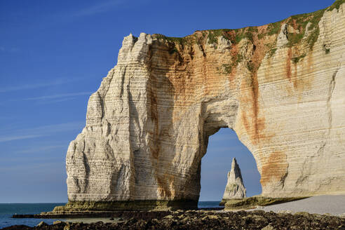 Chalk cliffs with natural arch on sunny day under blue sky - ANSF00617