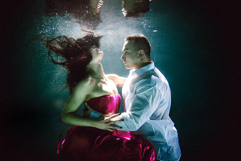 Couple swimming underwater with beautiful dress - Artistic dreamy portrait - DMDF04446