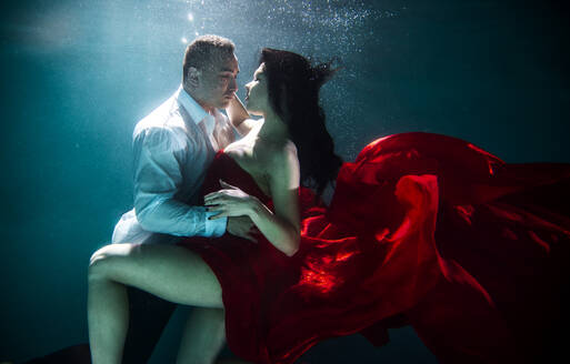 Couple swimming underwater with beautiful dress - Artistic dreamy portrait - DMDF04447