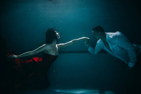 Couple swimming underwater with beautiful dress - Artistic dreamy portrait - DMDF04449