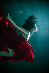 Beautiful woman swimming underwater with elegant dress - DMDF04455