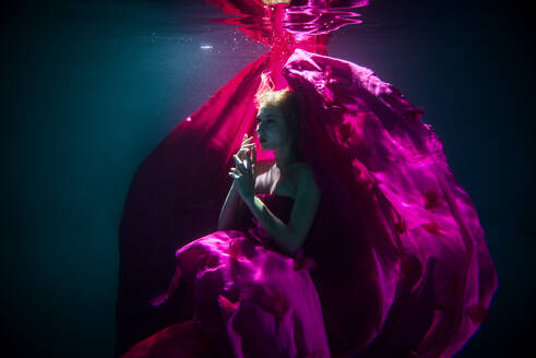 Beautiful woman swimming underwater with elegant dress - DMDF04457