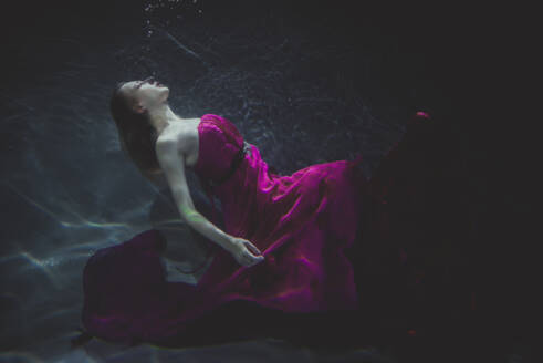 Beautiful woman swimming underwater with elegant dress - DMDF04458