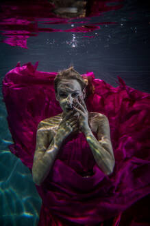 Beautiful woman swimming underwater with elegant dress - DMDF04459