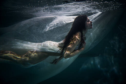 Beautiful woman swimming underwater with elegant dress - DMDF04462