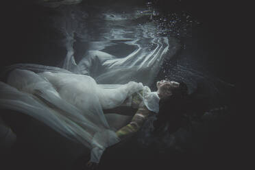 Beautiful woman swimming underwater with elegant dress - DMDF04464