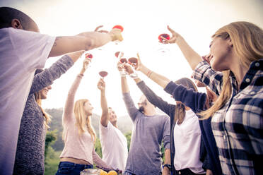 Gruppe von Freunden in einem Restaurant im Freien - Menschen beim Abendessen im Garten eines Hauses - DMDF04466