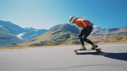 Cinematic downhill longboard session. Young woman skateboarding and making tricks between the curves on a mountain pass. Concept about extreme sports and people - DMDF04514