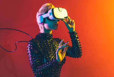 Darstellung eines bionischen Supermenschen mit fortschrittlichen Technologieteilen wie VR-Visoren und Gadgets, der in einem Mixed-Reality-Trainingsraum spielt. Futuristische Cyberpunk-Evolution der menschlichen Menschheit und KI - DMDF04591